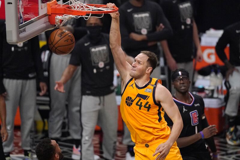 Utah Jazz forward Bojan Bogdanovic, left, dunks as Los Angeles Clippers guard Reggie Jackson watches.