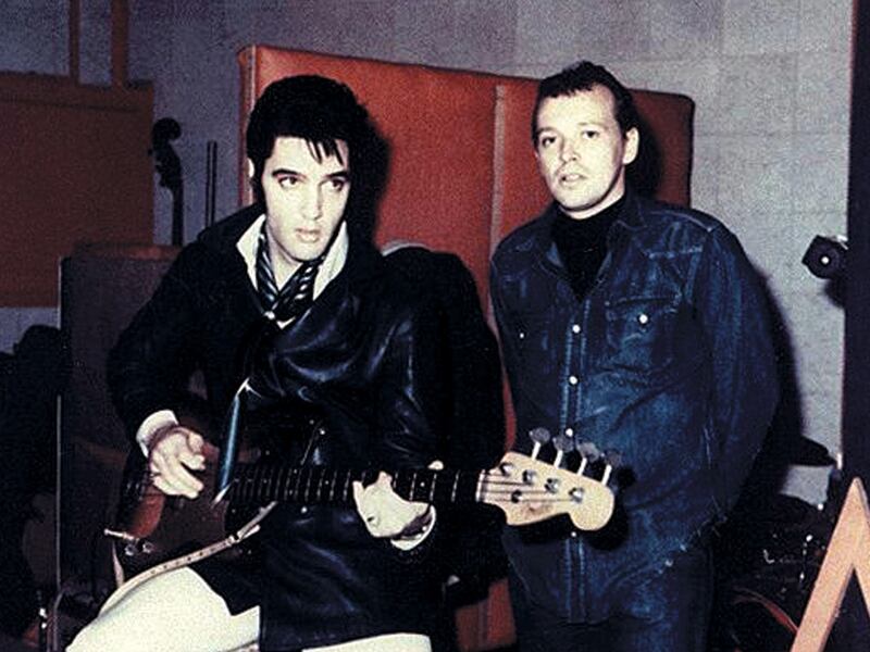 Elvis Presley holds a guitar with Chips Moman standing at American Sound Studio in Nashville, Tennessee.