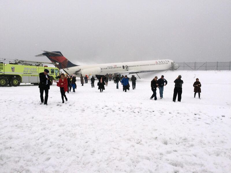 In this photo provided by Amber Reid, a passenger on Delta Flight 1086, passengers leave the plane after the aircraft skidded off the runway while landing, Thursday, March 5, 2015, at LaGuardia Airport in New York. Authorities said the plane, from Atlanta