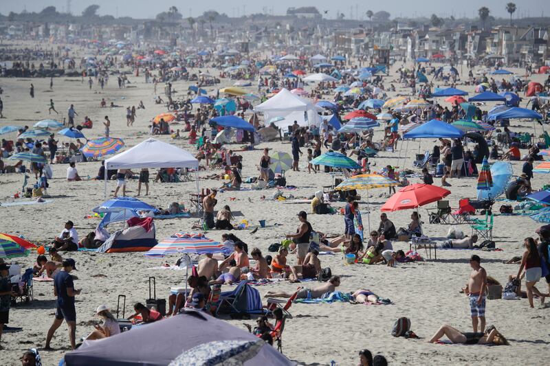 This May 24, 2020, file photo, shows visitors gathering on the beach in Newport Beach, Calif., during the coronavirus outbreak.