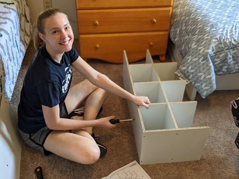 A young woman assembles furniture as part of an on-going service project to furnish apartments for incoming refugee families in Houston.