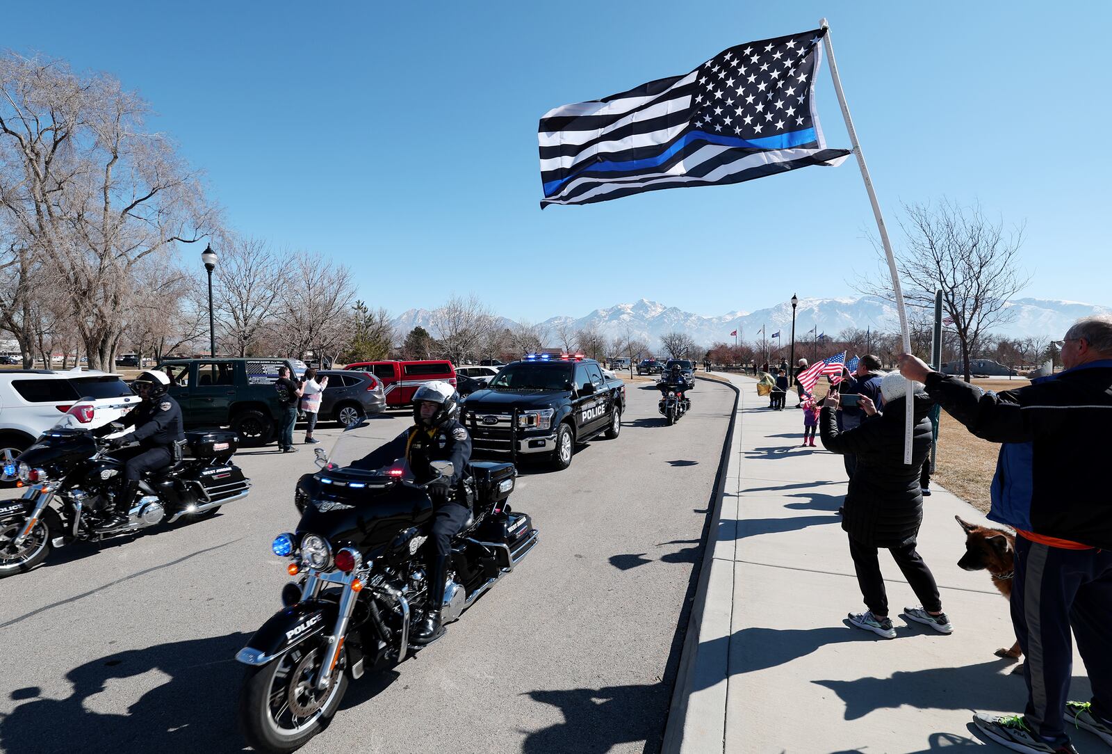 Gordan McChesney a flag as he, his wife, Janise McChesney, and their dog, Elphaba, gather at Veterans Memorial Park.