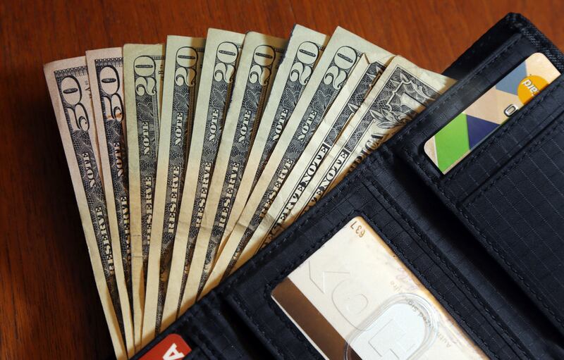 Cash is fanned out from a wallet in North Andover, Mass.