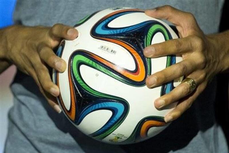 Brazilian soccer player Hernanes holds the 2014 World Cup official soccer ball, called Brazuca, after it was unveiled in Rio de Janeiro, Brazil, Tuesday, Dec. 3, 2013.