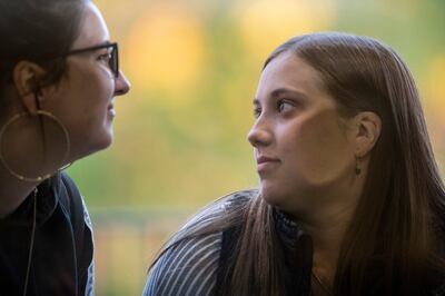 Two young women push their ears to the glass trying to hear Anita Hill speaking to a capacity crowd at the Obert C. and Grace A. Tanner Humanities Center at the University of Utah in Salt Lake City on Wednesday, Sept. 26, 2018.