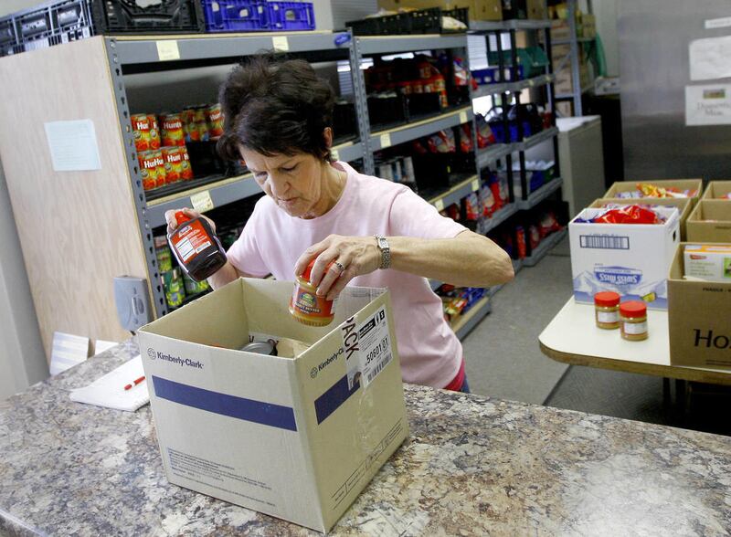 Volunteer Laura Vidrine stocks a food box in the pantry at Joshua's Storehouse on Friday afternoon in Casper. Food pantries for the needy around the state are experiencing a rise in demand as welfare benefits are cut back.