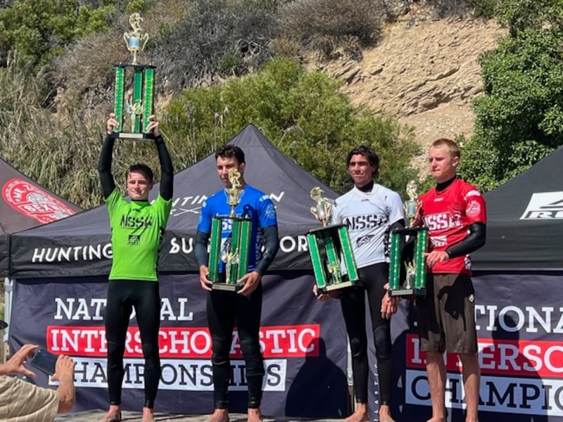 Saxson Baltzer holds his trophy overhead after winning the national surf championship in Huntington Beach, California.