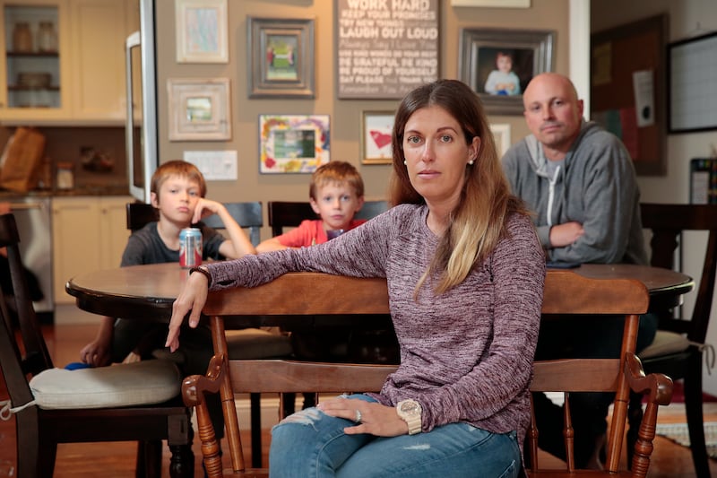 Kimberley Cashin poses for a portrait with her sons Connor, 7, left, Jack, 6, and husband John, at their home in Portola Valley, California, Friday, Nov. 10, 2017. Cashin pays over $1,800 per month for her non-Covered California health insurance plan. She