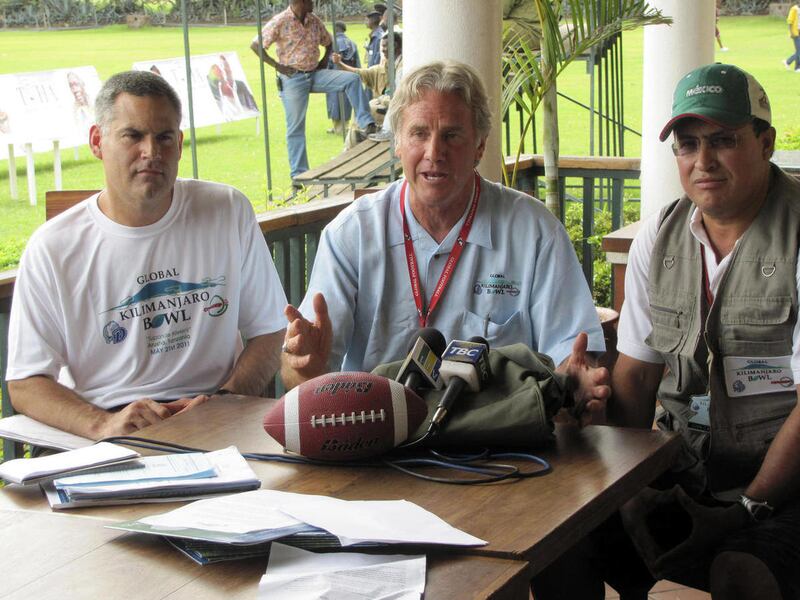 In this image provided by Global Football, Drake head coach Chris Creighton, left, event organizer Patrick Steenberge, center, and CONADEIP All-Stars head coach Juan Carlos Maya hold a news conference for the Kilimanjaro Bowl college football game, Thursd