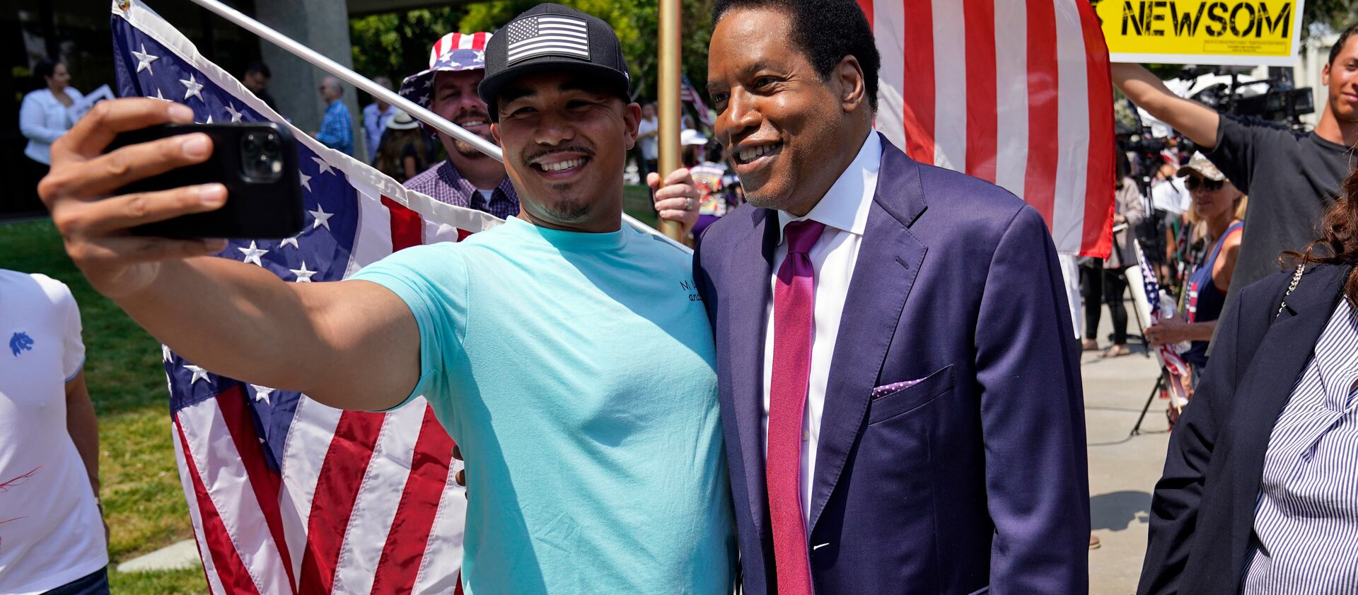 Radio talk show host Larry Elder poses for a selfie with a supporter during a campaign stop in Norwalk, Calif.