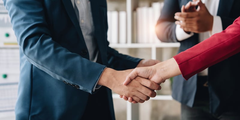 A man and woman shake hands.