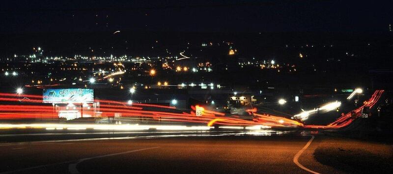 In a time exposure photo, tractor-trailers leave streaks of light as they merge onto Highway 2 west of Williston, N.D. As thousands of workers and their families move in search of jobs to North Dakota's Bakken oilfield, nearby Montana communities' resourc
