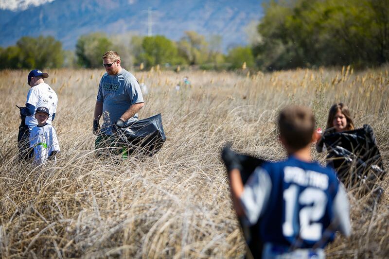 People pick up trash on the beaches of Utah Lake as a part of an Earth Day project in Vineyard on Saturday, April 22, 2017.