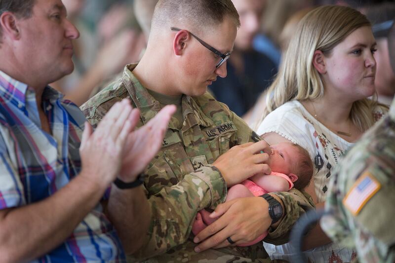 Robert Riddle of the Utah National Guard holds his almost 2-week-old daughter, Emma Riddle, before being deployed to the Middle East at the Roland R. Wright Air National Guard Base in Salt Lake City on Monday, June 4, 2018.