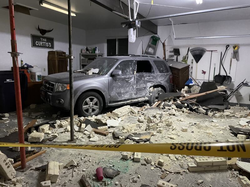 A garage and damaged vehicle are pictured after a truck hit a house on the 2500 East block of Alta Canyon Drive in Sandy on Tuesday.