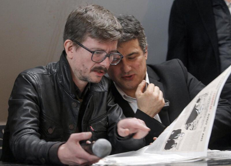 Renald Luzier, known as Luz, left, and columnist Patrick Pelloux, look at the Charlie Hebdo paper during a press conference in Paris, France, Tuesday, Jan. 13, 2015. The surviving staff of Charlie Hebdo is putting out an unprecedented 3 million copies of