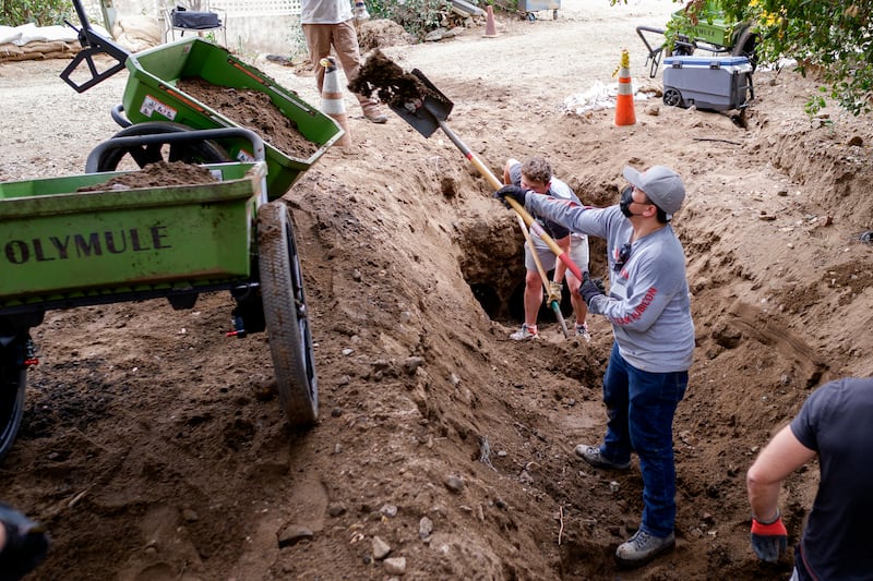 A member of Team Rubicon and a Latter-day Saint missionary clear damage after a wildfire on March 29, 2025, in El Cariso, California.
