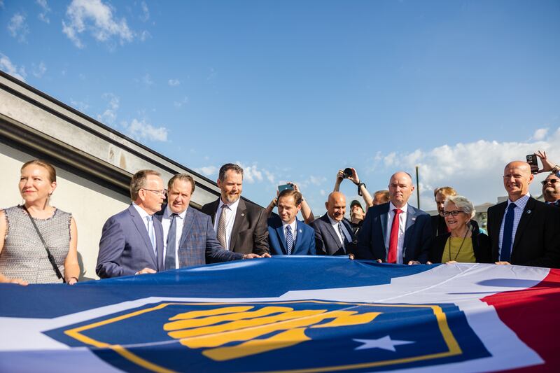 State officials including Gov. Spencer Cox and Senate President Stuart Adams, R-Layton, help raise the new Utah state flag on May 17, 2023.