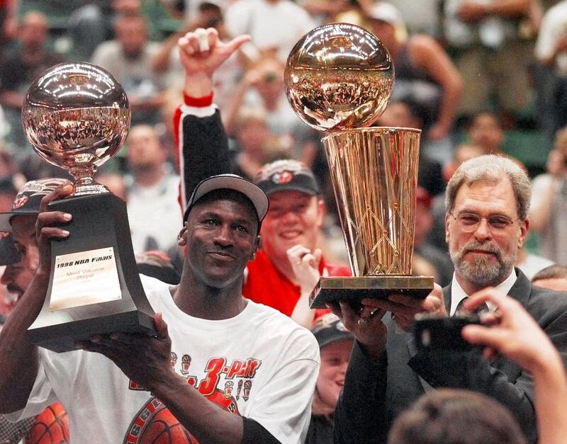 Chicago Bulls’ Michael Jordan, left, holds the Most Valuable Player trophy as coach Phil Jackson holds the NBA championship trophy after the Bulls defeated the Utah Jazz 87-86 in Game 6 of the NBA Finals in Salt Lake City, in this June 14, 1998 photo.