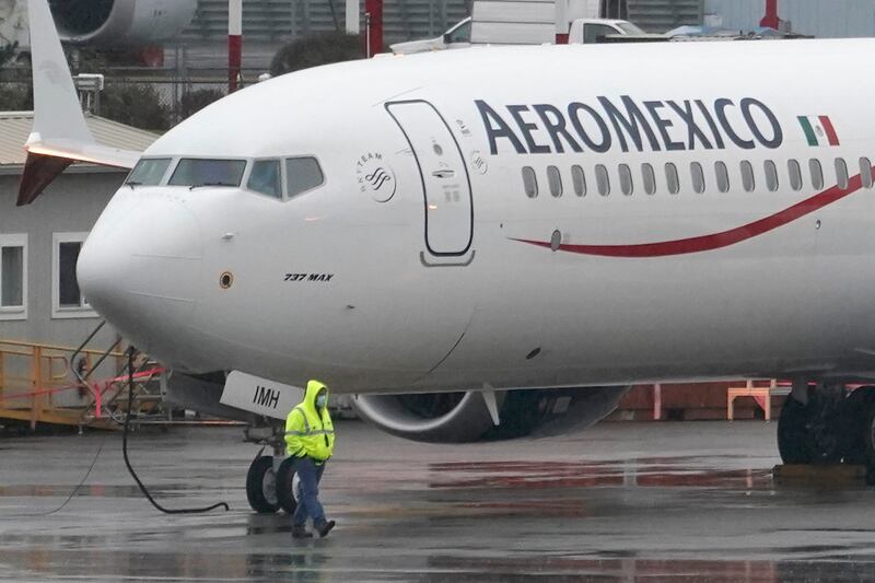 An airport worker walks past an Aeromexico Boeing 737 Max 9 in Renton, Washington.