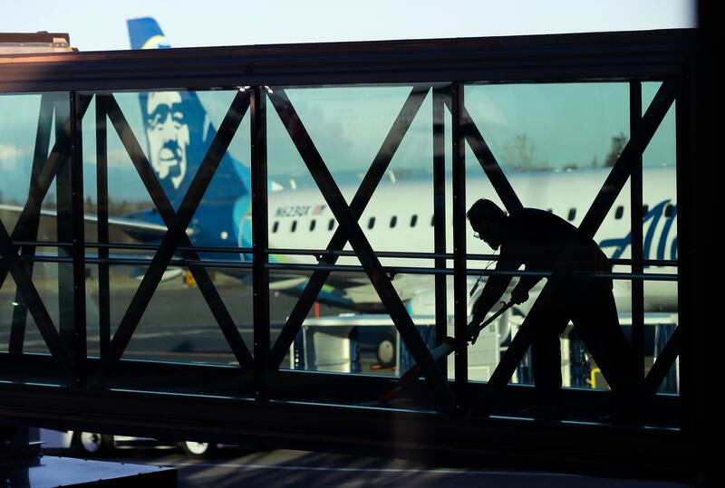 A worker cleans a jet bridge at Paine Field in Everett, Wash., before passengers board an Alaska Airlines flight on March 4, 2019.