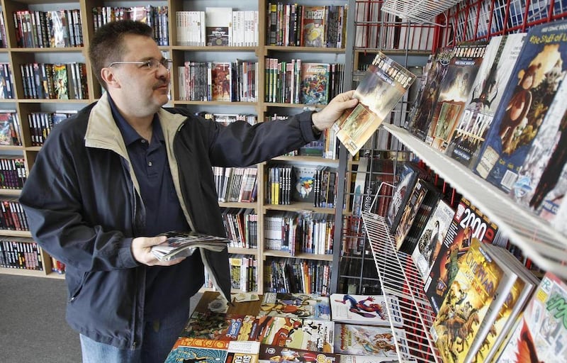 Ron Bufalini, from Ambridge, Pa., looks over the free comic books available at the New Dimensions Comics store on Free Comic Book Day, Saturday, May 7, 2011 in Cranberry, Pa.