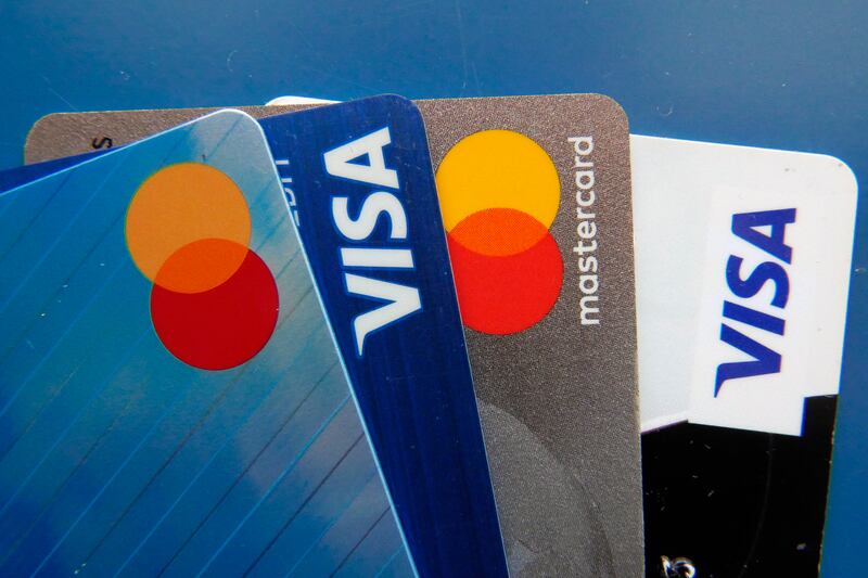 Four credit cards, two Visa cards and two Mastercards, are lined up together against a blue background.