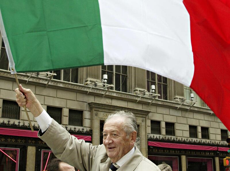 FILE - In this Monday, Oct. 10, 2005 file photo, Minister of Italians abroad, Mirko Tremaglia, waves a Italian flag during the 61st Annual Columbus Day Parade in New York. Tremaglia, a right-wing politician who successfully battled for the right of Italia