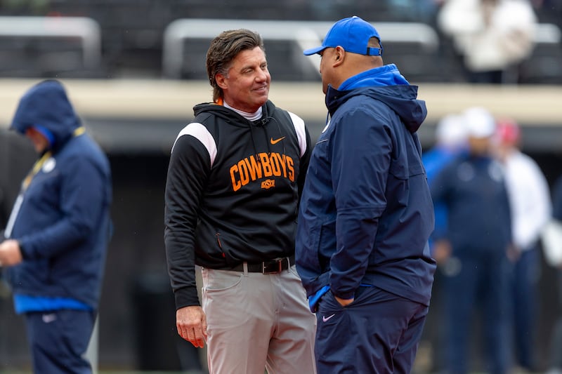 Oklahoma State head coach Mike Gundy and BYU head coach Kalani Sitake meet before a game Saturday, Nov. 25, 2023, in Stillwater, Okla.