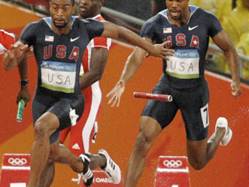 The baton falls between Darvis Patton, right, and Tyson Gay during the 4x100m relay. The drop eliminated the Americans.