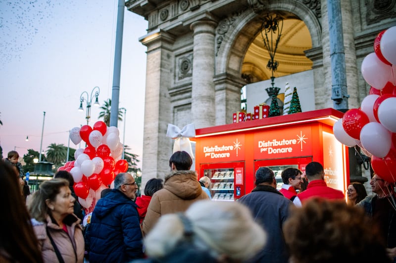 People gather around the new Giving Machines in Rome, Italy, ahead of the machines' launch event held at Piazza della Repubblica on Monday, Dec. 8, 2025.