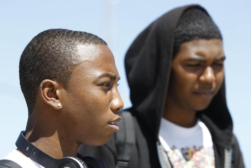 John Emmanuel, left, talks about Trayvon Martin, a 17-year-old who was shot and killed by a neighborhood watchman a couple of weeks ago in Sanford, Fla., as Mackenzie Baksh, right, looks on during an interview, Thursday, March 22, 2012, in Miami Gardens,