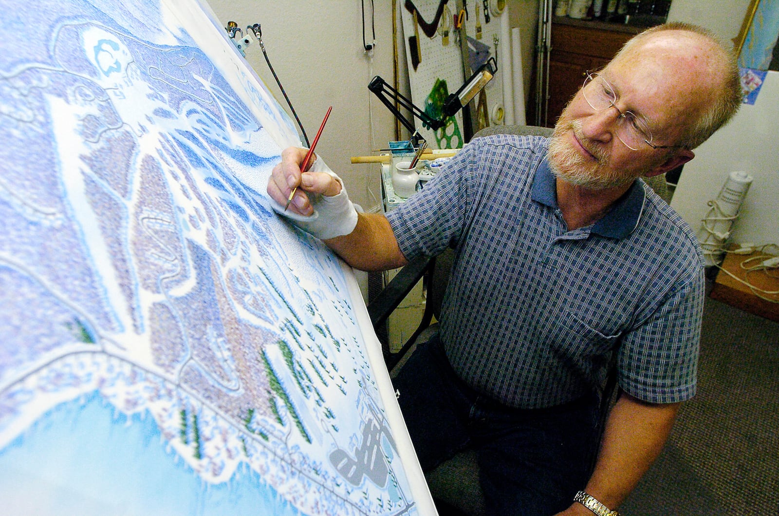 James Niehues paints a ski map.