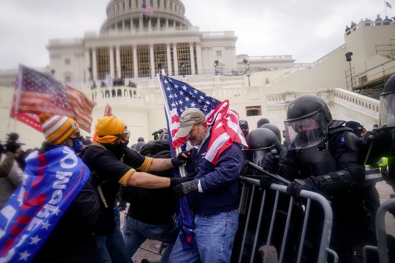 Rioters try to break through a police barrier at the Capitol on Jan. 6, 2021, in Washington.