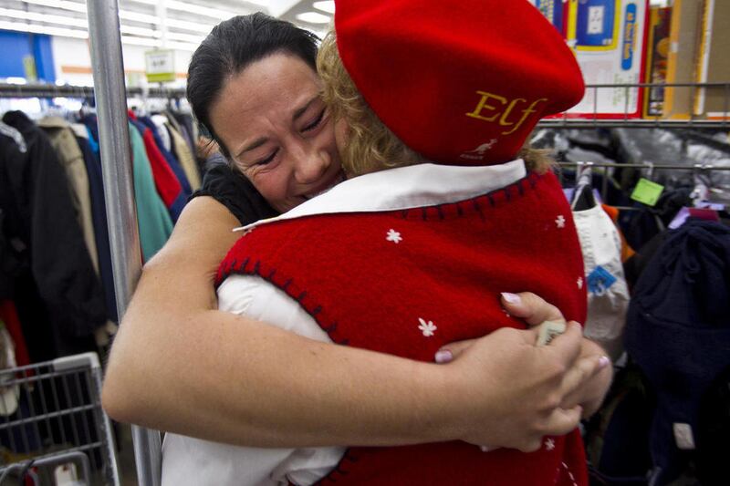 In this Thursday, Dec. 16, 2010 photo, Angelina Sage of Glendale, gives a Secret Santa elf a hug after receiving a $100 bill at a Goodwill store in Phoenix. Now in the fifth year, Secret Santa and the elves carry on the tradition of anonymously handing ou