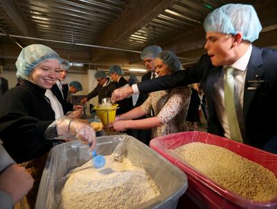 Missionaries at the Missionary Training Center in Provo work to fill bags of "Apple Pie Oats" as they participate in an annual service project with Feeding Children Everywhere to address the issue of domestic hunger. Working in a covered parking garage at