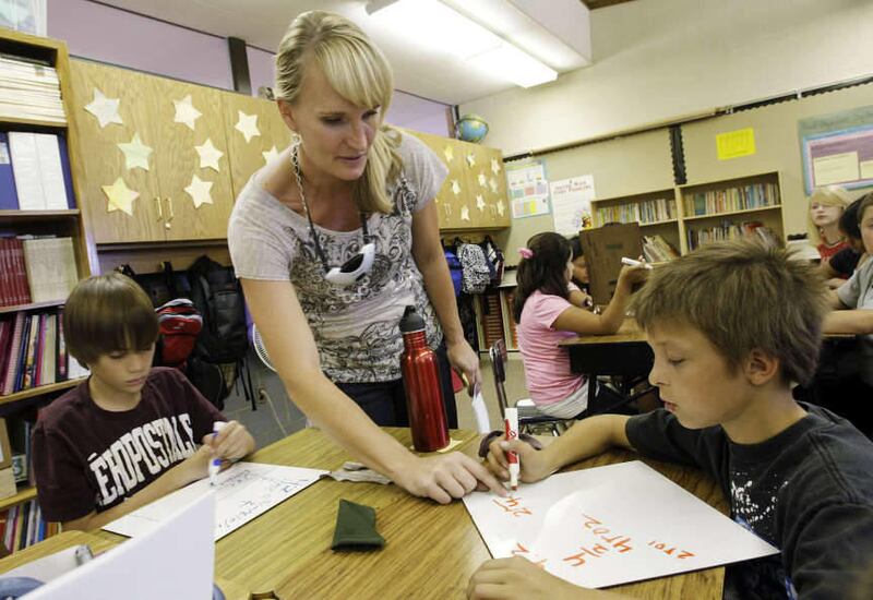 Arcadia Elementary School 6th grade teacher Stacy Jones works with students Kurt Bach (L) and Isaac Fuguer in Taylorsville Thursday, Sept. 8, 2011. The school has been a great example of using differentiated instruction and it has helped Jones\' class imp