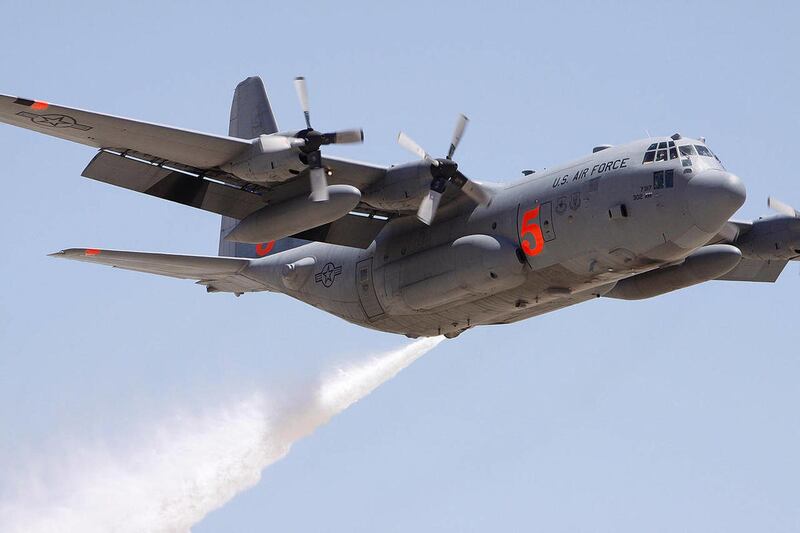 FILE - In this May 6, 2009 file photo, a Colorado Reserve C-130 drops water on a target during a certification flight at the Tucson International Airport in Tucson, Ariz. Military cargo planes used to drop slurry on wildfires are now based in Utah and Ida