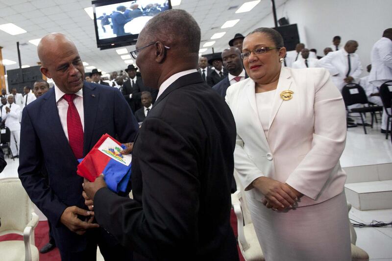 Haiti's outgoing President Michel Martelly, left, returns the presidential sash to Senate leader Jocelerme Privert, after Martelly delivered his farewell speech at Parliament in Port-au-Prince, Haiti, Sunday, Feb. 7, 2016. Martelly left office Sunday wit