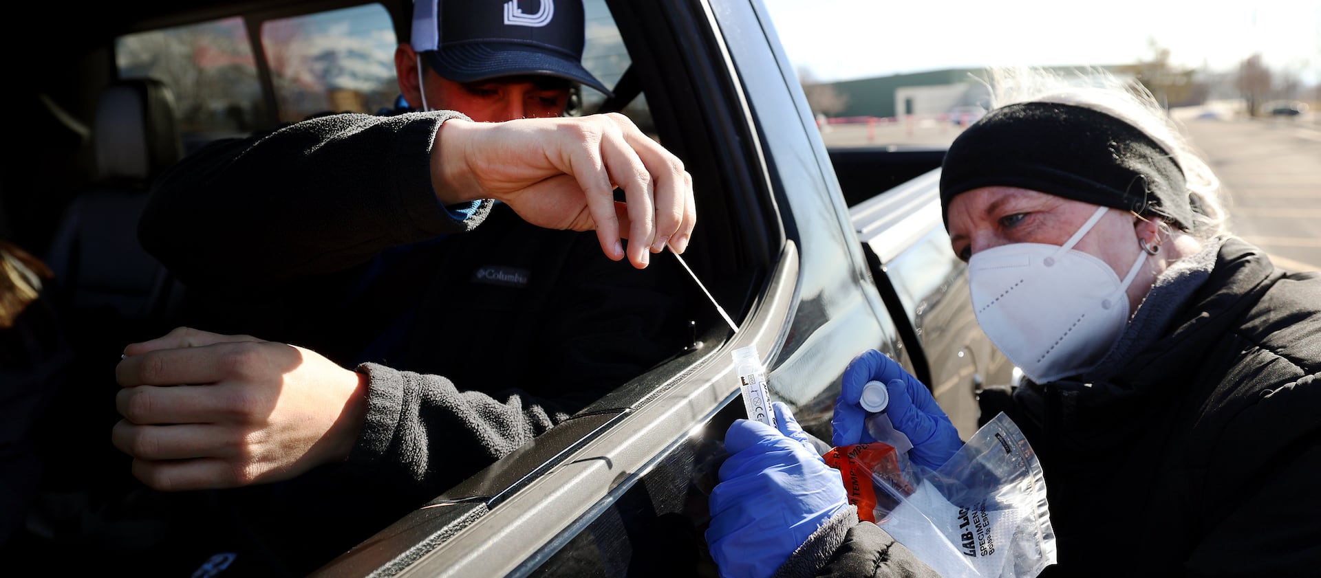 Registered nurse Paula Moffitt collects a COVID-19 nasal swab from Nathan Graham at the University of Utah in Salt Lake City on Monday, Jan. 31, 2022.