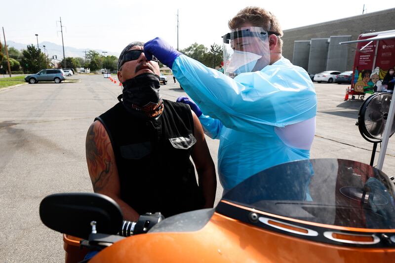 Dakota Silva administers a COVID-19 test to Bernard Montes as University of Utah Health’s Wellness Bus visits the Sorenson Multicultural Center in Salt Lake City on Thursday, Aug. 20, 2020.