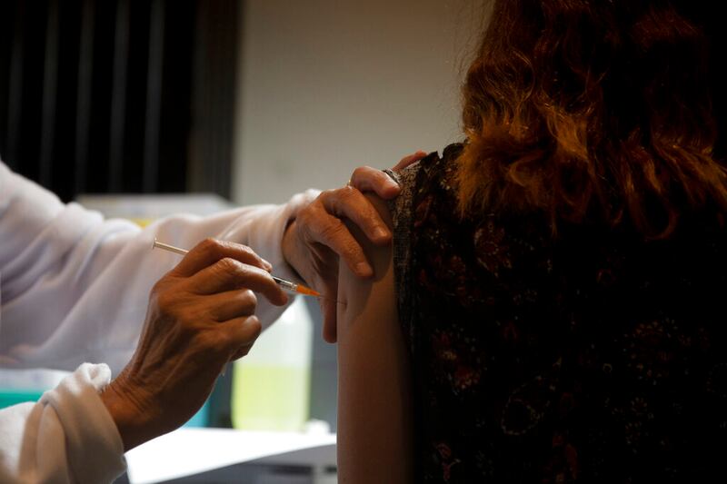 A medical professional administers a booster shot for the coronavirus vaccine.