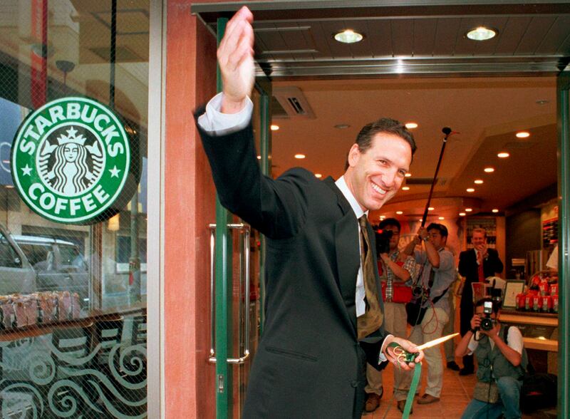 In this Aug. 2, 1996, file photo, Howard Schultz, chairman and chief executive officer of Starbucks Coffee Co., waves after cutting the ribbon to inaugurate its store in Tokyo's Ginza shopping district. For someone who has given about $150,000 to Democrat