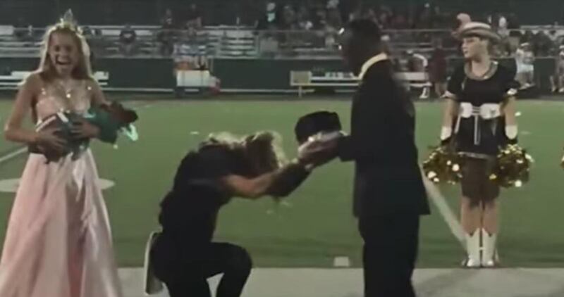 Max Akin kneels and presents homecoming crown to his friend, K.L. Norwood.