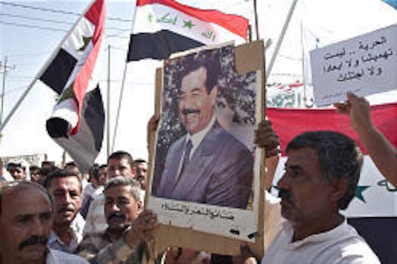 Protesters carry a poster of Saddam Hussein as they rally against the new constitution in the predominantly Sunni city of Baqouba, Iraq, Friday. The photos appeared for the first time in public since the former dictator was arrested in December 2003.