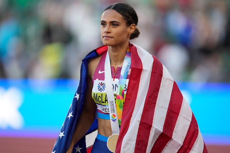 Sydney McLaughlin walks with the American flag over her shoulders after winning the gold medal at the World Athletics Championships.