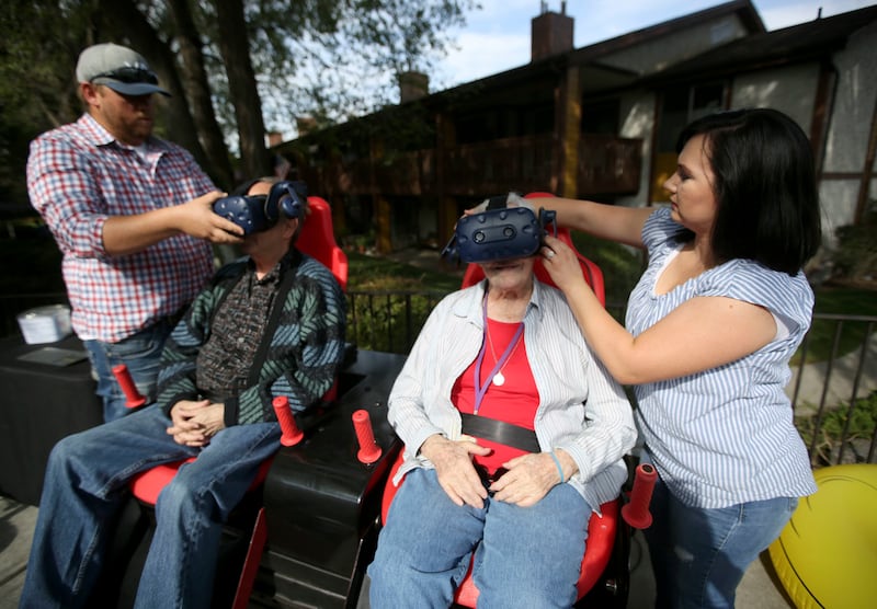Daniel Thompson, Innovative Entertainment owner and creator, helps Alden Tueller put on a virtual reality headset as Amber Thompson, Innovative Entertainment event coordinator, helps Laurie Coon put hers on to experience “Soaring Southern Utah,” a virtual