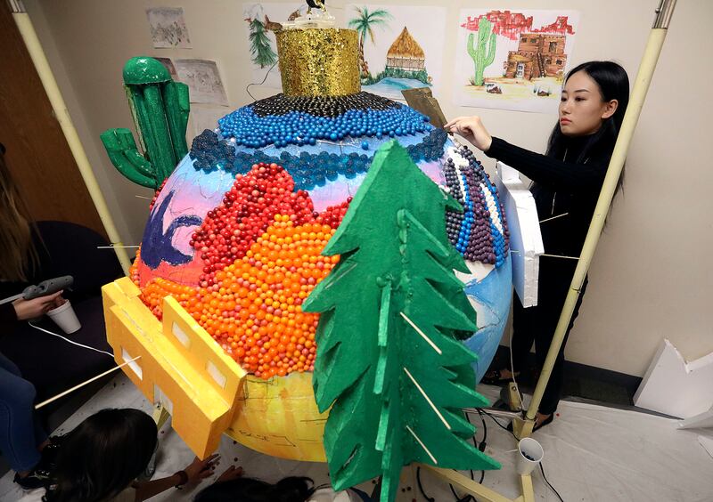 Yukako Ogura glues candy on "One Sky" for Macy's Candy Windows at Salt Lake Community College in Salt Lake City on Monday, Oct. 22, 2018.