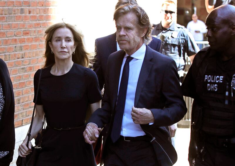 Felicity Huffman arrives at federal court with her husband William H. Macy for sentencing in a nationwide college admissions bribery scandal, Friday, Sept. 13, 2019, in Boston. (AP Photo/Elise Amendola)