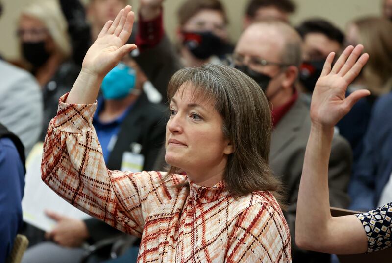 Nicholeen Peck, president of Worldwide Organization for Women, raises her hand before giving a public comment supporting SB114.